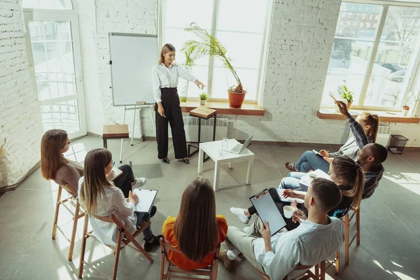 Ponente mujer caucásica dando presentación en salón en taller universitario o de centro de negocios — Foto de Stock