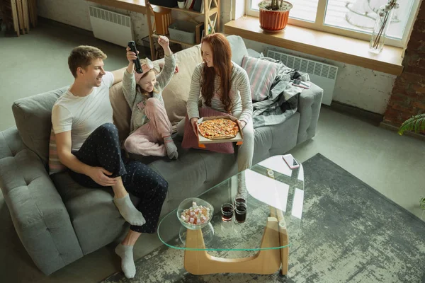 Familia pasar un buen tiempo juntos en casa, se ve feliz y alegre, comer pizza —  Fotos de Stock