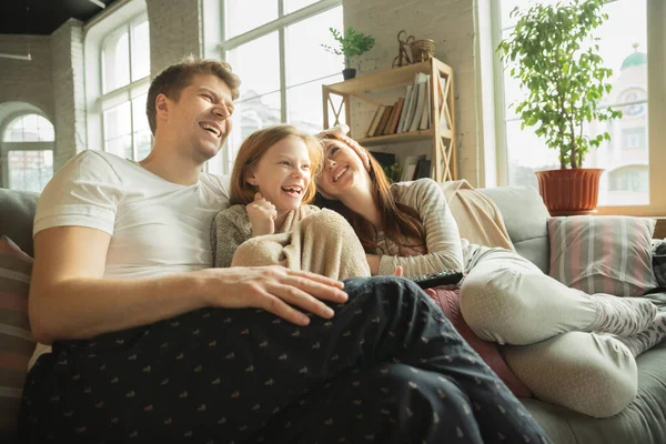 Familjen spenderar trevlig tid hemma, ser glad och glad ut, äter pizza — Stockfoto