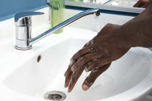 Man wassen handen voorzichtig in de badkamer close-up. Preventie van infectie en verspreiding van longontsteking — Stockfoto