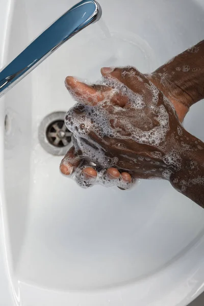 Az ember óvatosan mos kezet a fürdőszobában, közelről. A fertőzés és a tüdőgyulladás vírussal való terjedésének megelőzése — Stock Fotó