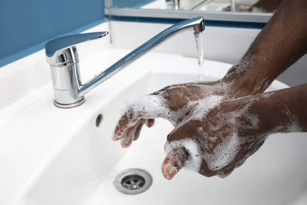 男は慎重にバスルームで手を洗うを閉じる。感染の予防と肺炎ウイルスの蔓延 — ストック写真