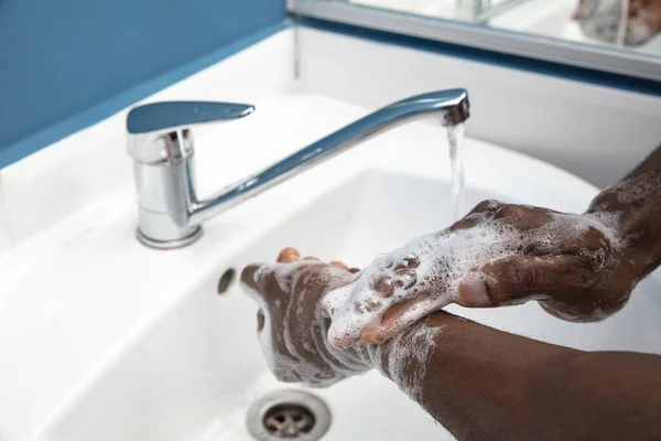 Man wassen handen voorzichtig in de badkamer close-up. Preventie van infectie en verspreiding van longontsteking — Stockfoto