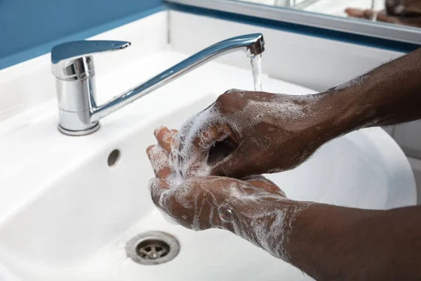 Hombre lavándose las manos cuidadosamente en el baño de cerca. Prevención de infecciones y propagación del virus de la neumonía —  Fotos de Stock