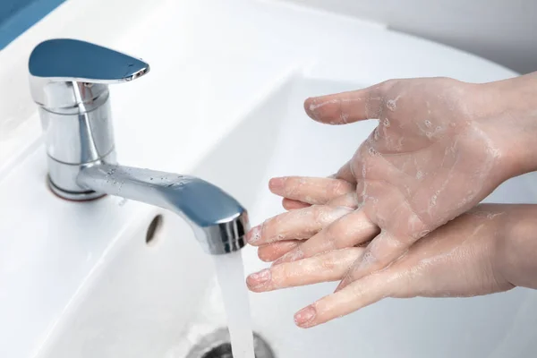A nő óvatosan mos kezet a fürdőszobában, közelről. A fertőzés és a tüdőgyulladás vírussal való terjedésének megelőzése — Stock Fotó