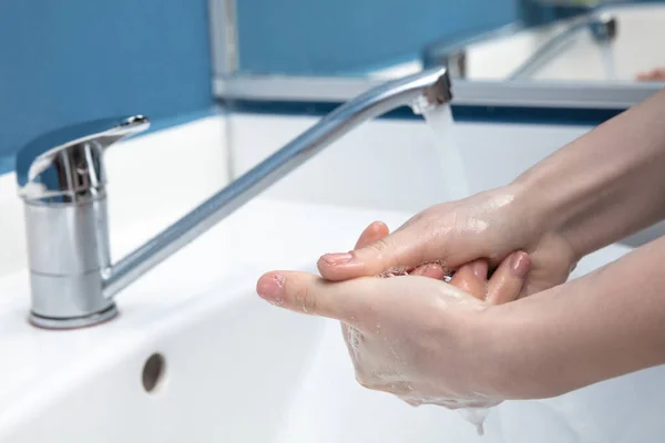 Vrouw wassen handen zorgvuldig in de badkamer close-up. Preventie van infectie en verspreiding van longontsteking — Stockfoto