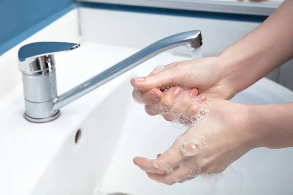 Vrouw wassen handen zorgvuldig in de badkamer close-up. Preventie van infectie en verspreiding van longontsteking — Stockfoto