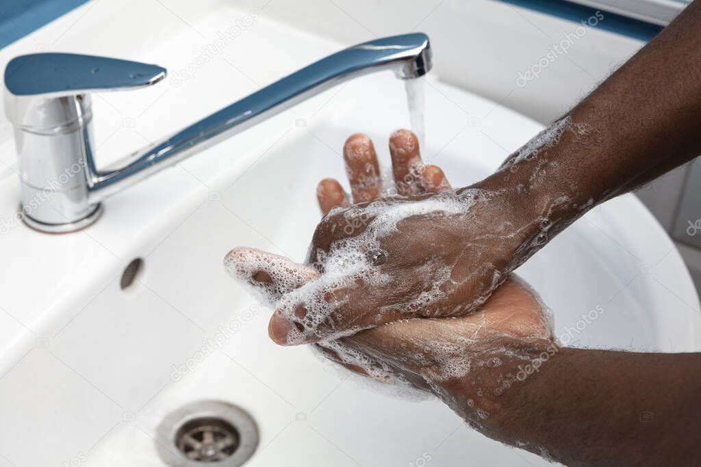 Man washing hands carefully in bathroom close up. Prevention of infection and pneumonia virus spreading