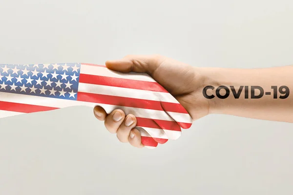 在美利坚合众国国旗上涂色的人的手和验尸官的手-病毒传播的概念 — 图库照片