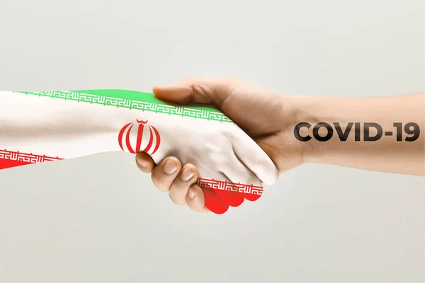 Human hands colored in flag of Iran and coronavirus - concept of spreading of virus — Stock Photo, Image