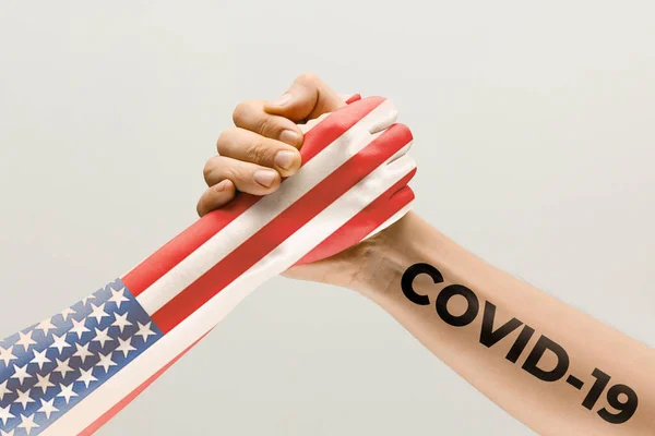 Ludzkie ręce kolorowe w fladze Stanów Zjednoczonych Ameryki i koronawirusa - koncepcja rozprzestrzeniania się wirusa, walki. — Zdjęcie stockowe