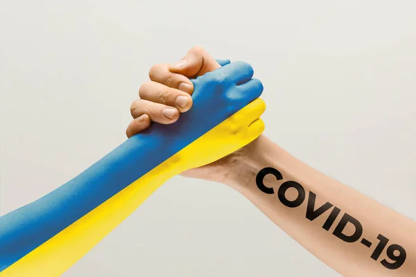 Human hands colored in flag of Ukraine and coronavirus - concept of spreading of virus, fighting — Stock Photo, Image