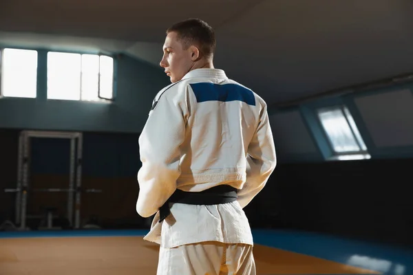 Ung judo fighter i kimono poserar comfident i gymmet, stark och frisk — Stockfoto