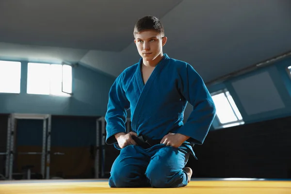 Ung judo fighter i kimono poserar comfident i gymmet, stark och frisk — Stockfoto