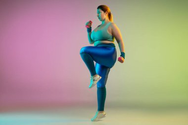 Genç Kafkasyalı artı boy kadın modeller gradyan mor arka plan eğitimi alıyorlar.