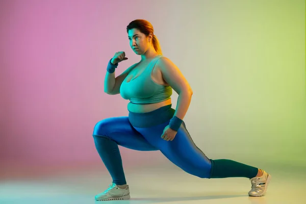 Jeune caucasien plus la taille des modèles féminins formation sur dégradé violet fond vert — Photo