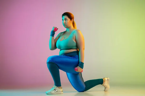 Jeune caucasien plus la taille des modèles féminins formation sur dégradé violet fond vert — Photo