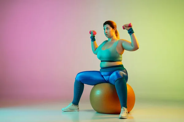 Jeune caucasien plus la taille des modèles féminins formation sur dégradé violet fond vert — Photo