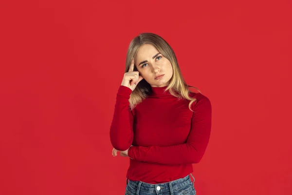 Monochrome portrait of young caucasian blonde woman on red background — Stock Photo, Image