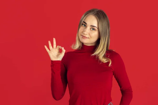 Retrato monocromático de jovem mulher loira caucasiana no fundo vermelho — Fotografia de Stock