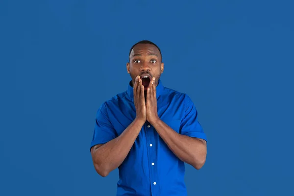 Monochroom portret van jonge Afrikaans-Amerikaanse man op blauwe studio achtergrond — Stockfoto