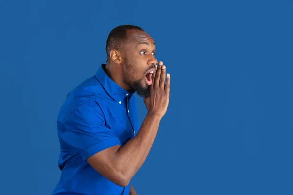 Monochroom portret van jonge Afrikaans-Amerikaanse man op blauwe studio achtergrond — Stockfoto