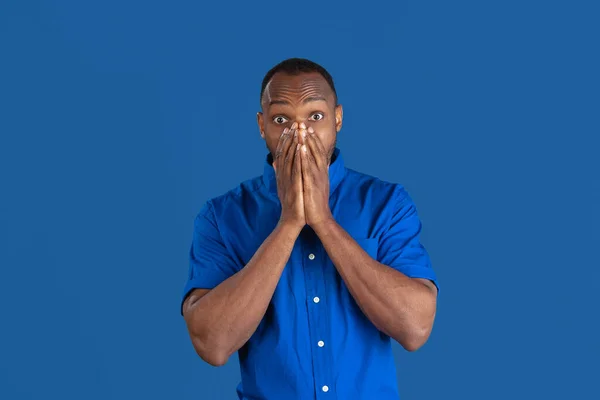 Monochromatyczny portret młodego afrykańsko-amerykańskiego mężczyzny na niebieskim tle pracowni — Zdjęcie stockowe