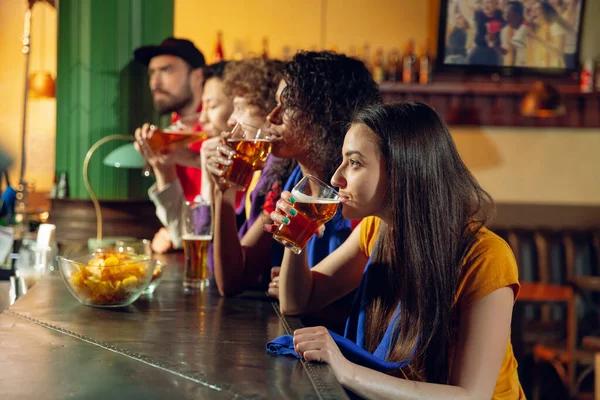 Fãs do esporte torcendo no bar, pub e bebendo cerveja enquanto campeonato, a competição está indo — Fotografia de Stock