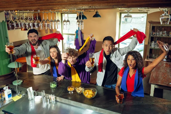 Sport fans juichen in de bar, pub en het drinken van bier, terwijl het kampioenschap, de concurrentie gaat — Stockfoto