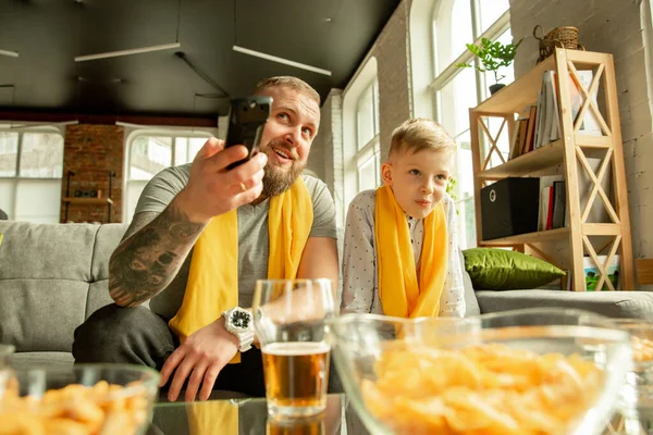 Spännande familj titta på fotboll, sport match hemma, far och son — Stockfoto