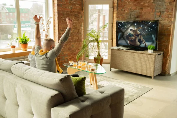 Spännande familj tittar på kampsport, sport match hemma, far och son — Stockfoto