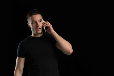 Siyah stüdyo arka planında beyaz bir gencin tek renkli portresi.