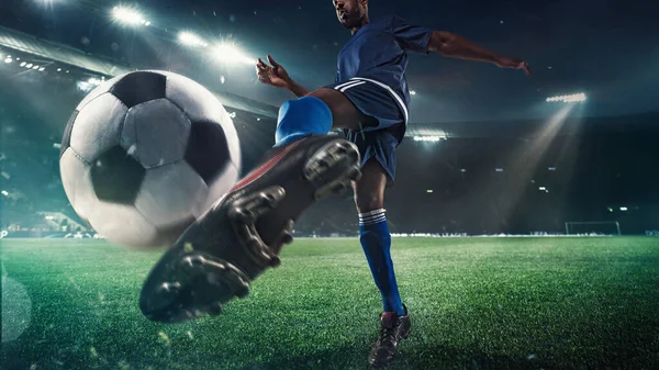 Joueur de football ou de soccer en action sur le stade avec des lampes de poche, ballon de tir pour but gagnant, grand angle — Photo