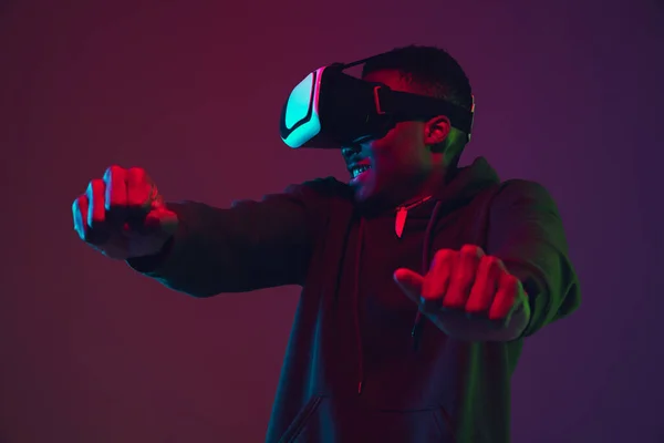 Afrikai-amerikai férfiak portré VR-headset elszigetelt gradiens stúdió háttér neon fény — Stock Fotó