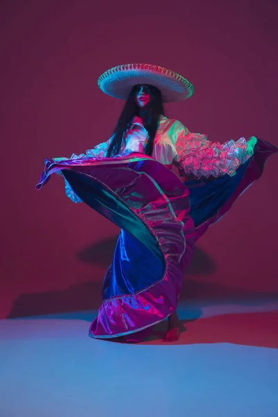 Fabuloso Cinco de Mayo dançarina feminina no fundo do estúdio roxo em luz de néon — Fotografia de Stock