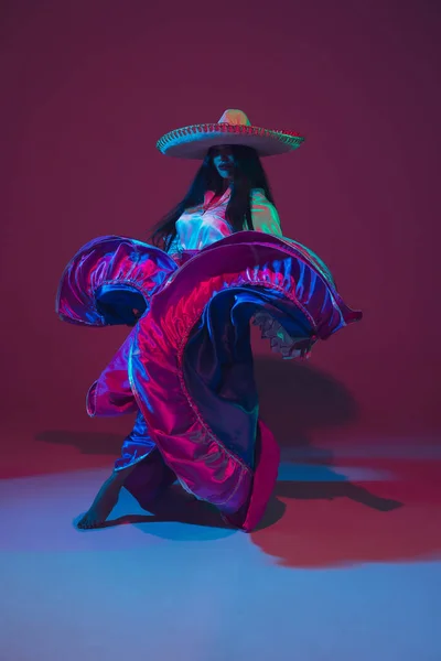 Fantastyczny Cinco de Mayo kobieta tancerka na fioletowym tle studio w świetle neonu — Zdjęcie stockowe