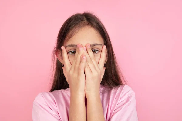 Vit liten flicka porträtt isolerad på rosa studio bakgrund, känslor koncept — Stockfoto