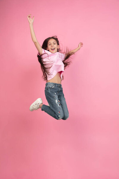 Caucasian little girl portrait isolated on pink studio background, emotions concept