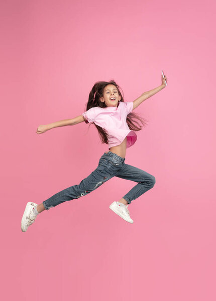 Caucasian little girl portrait isolated on pink studio background, emotions concept