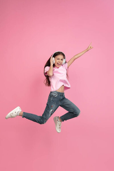 Caucasian little girl portrait isolated on pink studio background, emotions concept