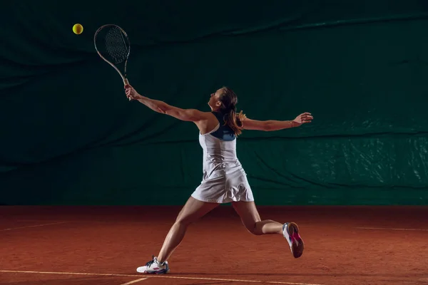 Jonge Kaukasische professionele sportvrouw spelen tennis op sportveld achtergrond — Stockfoto