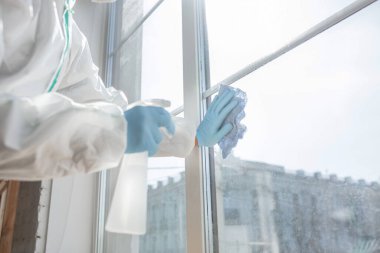 Koronavirüs salgını. Koruyucu giysinin içindeki bir dezenfektan evde ya da ofiste dezenfektan püskürtür.
