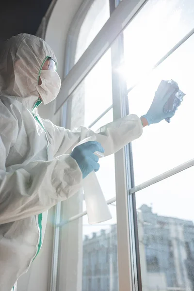 Coronavirus Pandemic. Disinfektor dalam pakaian pelindung dan masker menyemprotkan disinfektan di rumah atau kantor — Stok Foto