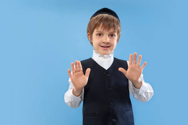 Portrait d'un jeune garçon juif orthodoxe isolé sur fond de studio bleu, rencontrant la Pâque — Photo