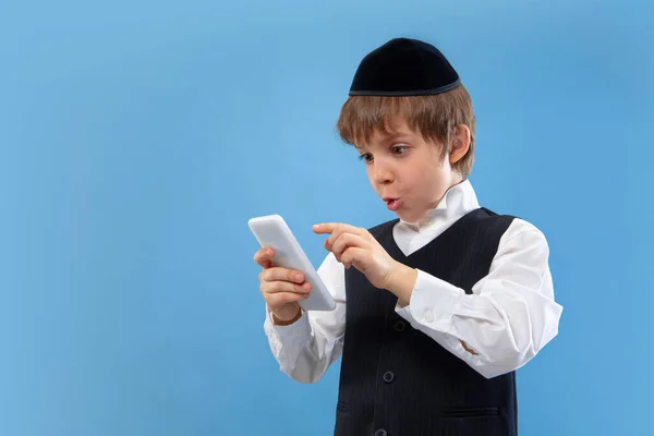 Porträt eines jungen orthodoxen jüdischen Jungen isoliert auf blauem Studiohintergrund, der das Pessach trifft — Stockfoto