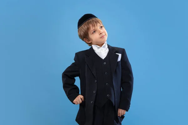 Portrait d'un jeune garçon juif orthodoxe isolé sur fond de studio bleu, rencontrant la Pâque — Photo