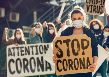 Young people in face masks protesting of stop coronavirus pandemic on the street clipart