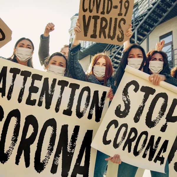 Unga människor i ansiktsmasker protesterar mot stoppet för coronavirus pandemi på gatan — Stockfoto