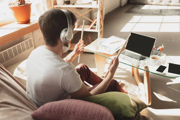 Jeune homme étudiant à la maison pendant les cours en ligne pour musicien, batteur, producteur — Photo