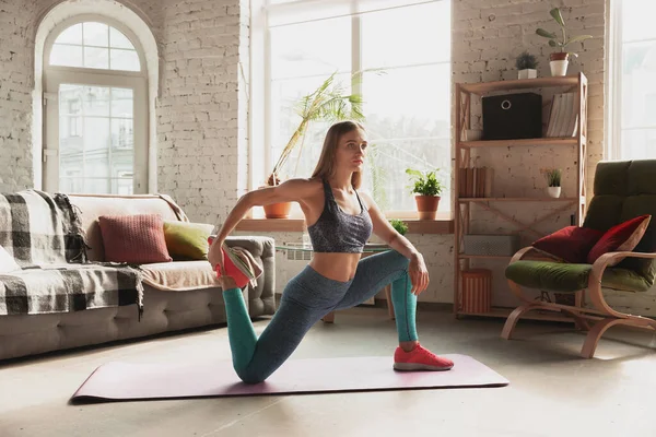 Jonge vrouw geeft thuis online cursussen fitness, aerobic, sportieve levensstijl terwijl ze in quarantaine is — Stockfoto